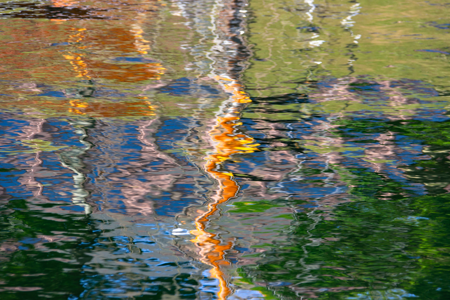 Verschwommene Spiegelung eines Segelschiffs im Hafenbecken in Kiel